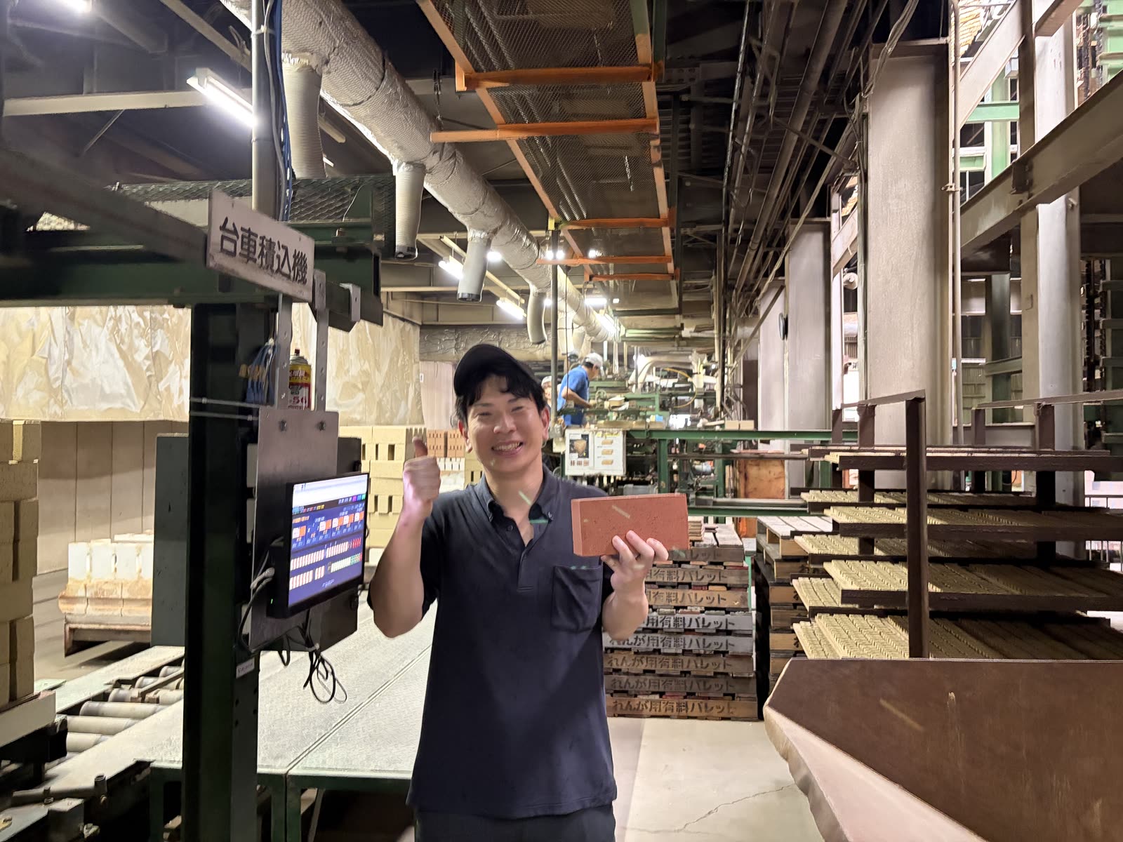 導入後、煉瓦を手に笑顔でガッツポーズをするお客様